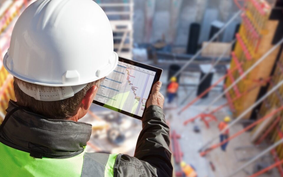 man looking at digital document on tablet at construction site